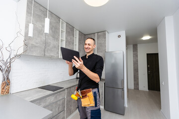 Worker with tablet computer checking alarm system indoors