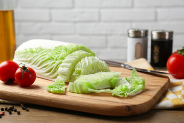 Cut fresh Chinese cabbage, tomatoes and spices on wooden table