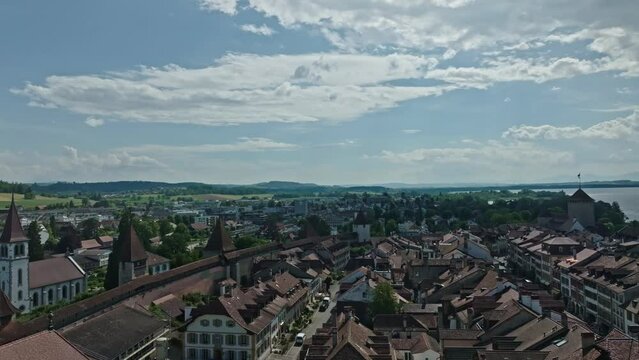 Aerial view of medieval old town of Swiss City of Murten Morat with lake in the background on a cloudy spring day. Movie shot June 5th, 2024, Murgen Morat, Switzerland.