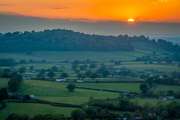 Beautiful sunset at english countryside nearby Batcombe in Dorset County, setting sun and dramatic clouds over the hills and farmlands