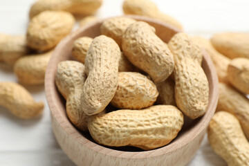 Fresh peanuts in bowl on table, closeup