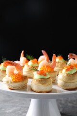 Different delicious puff pastry snacks on table