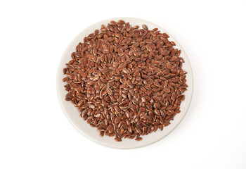 Top view of Brown flax seeds on white plate isolated on white background. Brown Flax Seed is rich in nutrients such as dietary fiber and essential fatty acids that are beneficial to the body.