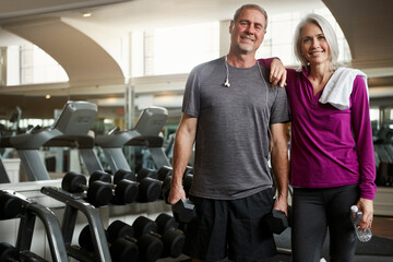 Mature couple, fitness and portrait at gym, smile and dumbbell for training, bottle and exercise...