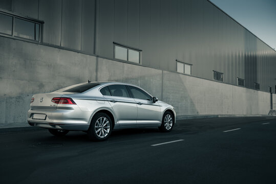 Silver Volkswagen Passat parked near warehouse. Perspective rear three quarter view of german sedan near grey concrete wall. Kyiv, Ukraine - August 05 2015.