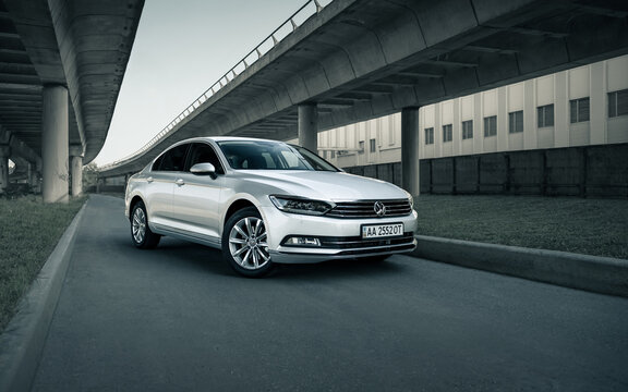 Silver Volkswagen Passat under two bridges. Perspective front three quarter view of german sedan in urban setting. Kyiv, Ukraine - August 05 2015.