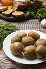 Tasty young boiled potatoes on wooden table