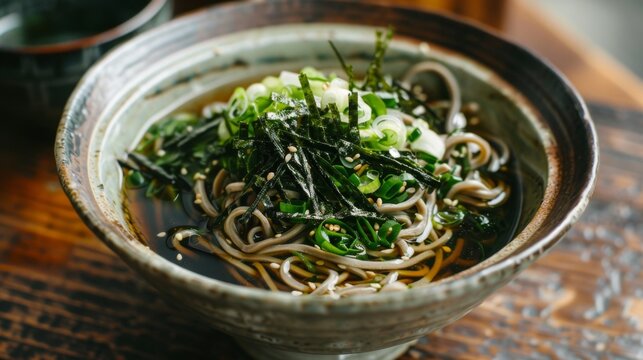 A bowl of cold soba noodles topped with wakame seaweed, sliced green onions, and a splash of soy sauce, a refreshing and light Japanese dish