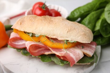 Tasty sandwich with bacon and bell pepper on white table, closeup