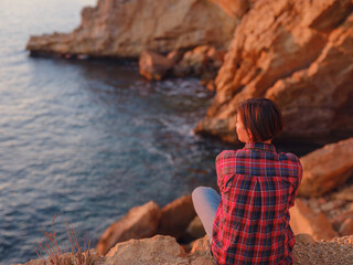 Young woman hiking on rocky beach in Spain, Benidorm