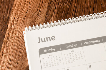 White calendar of the month of June on a wooden background. Planning, goal setting, agenda, planner, organization and time management concept.