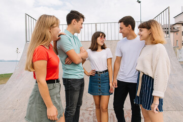 Fototapeta premium Summer holidays and teenage concept - group of smiling teenagers hanging out outside.