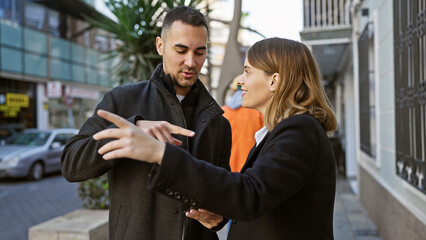 A woman and man engaging in conversation on a busy urban street, exuding a sense of connection.