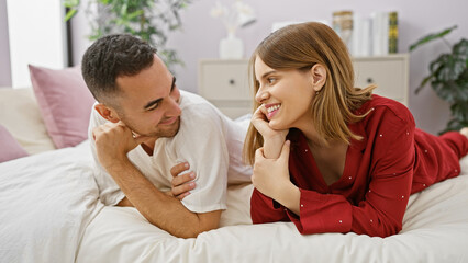 Fototapeta premium A loving couple enjoys a relaxed, intimate moment together in a cozy bedroom setting, exemplifying romance and affection.