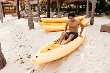 Serene Summer Kayaking Adventure: A Happy Asian Man in a Colorful Hat Enjoying the Tropical Beach...