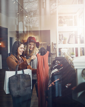 Shopping, boutique and girl friends by clothes in retail mall for discount, sale or promotion. Style, window and young women bonding and buying designer outfit on rack at luxury fashion store.
