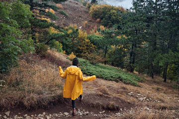 Exploring the Beauty of Nature A Woman in a Yellow Raincoat Enjoying a Peaceful Walk Through the Woods