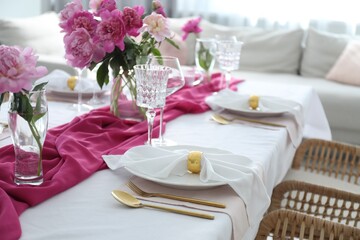 Beautiful table setting with pink peonies in dining room