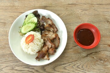 slice grilled fermenting porkwith milk topping rice eat couple cucumber and lettuce dipping spicy barbecue sauce on plate 