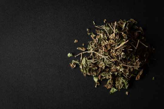 A pile of Dry Organic Gymnema or Gurmar (Gymnema sylvestre) leaves, isolated on a black background. Top view