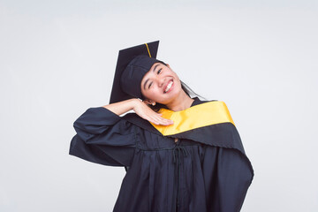 Silly young woman in graduation attire gloats and shows off. A graduate of bachelor of science....