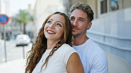 A joyful couple embracing outdoors on a city street, embodying love, relationship, and happiness against an urban backdrop.