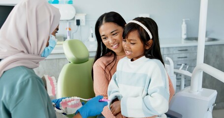 Child, dentist or education of brushing teeth in office or family friendly demonstration of tooth hygiene. Girl, parent or pediatric orthodontist with dental model to brush or lesson on mouth care