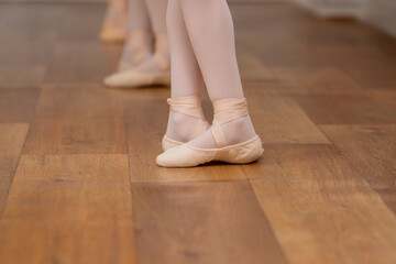 close up of legs professional ballet school for children girls in green bodysuit training at the barre