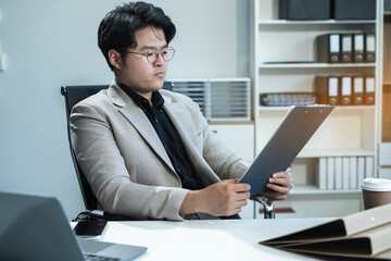 Business man working at office with laptop and documents on desk, financial adviser analyzing data.