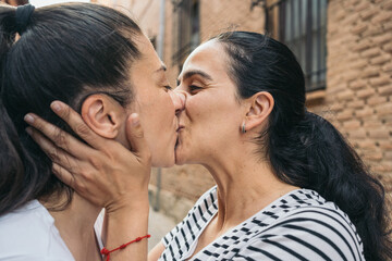 Intimate moment between loving couple. Close-up of a tender kiss shared by a couple on a city street