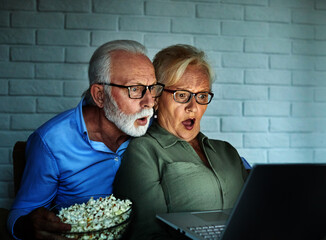 television watching couple laptop night home evening horror scared elderly senior mature active old...