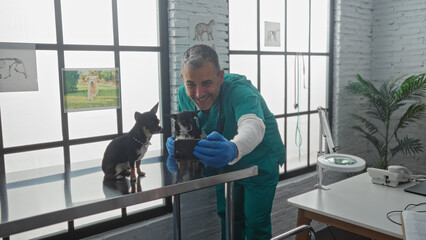 Middle-aged hispanic man in a veterinary clinic taking a selfie with two chihuahuas on a metal...