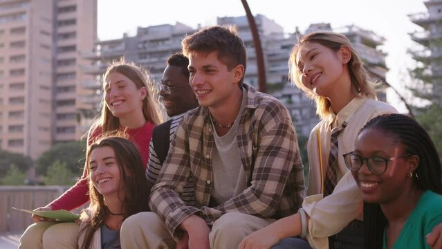 Young student colleague standing smiling and posing for photo looking at camera with her multiracial college classmates on university campus. Group of cheerful generation z friends together outdoors