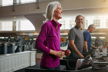 Exercise, treadmill and senior people running in gym for workout, physical health and wellness in...