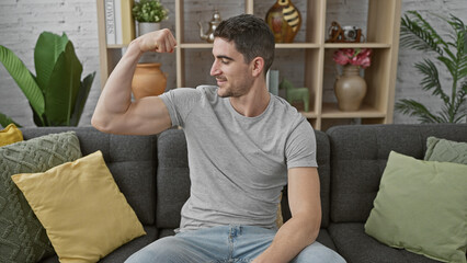 Handsome young man flexing muscles proudly in a cozy modern living room.