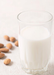 Vegan dairy free almond milk and almonds on white wooden background. Selective focus, space for text.
