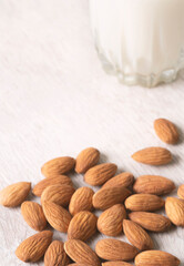 Vegan dairy free almond milk and almonds on white wooden background. Selective focus, space for text.