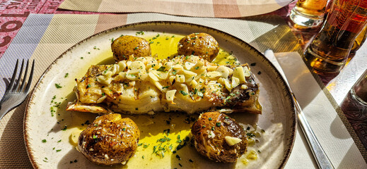 Typical portuguese dish roasted codfish with onion garlic peppers and rustic potatoes