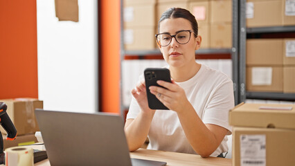 Young beautiful hispanic woman ecommerce business worker using smartphone at the office