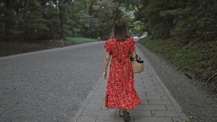 Beautiful hispanic woman with glasses pauses, walking away from meiji temple, capturing the enigma...