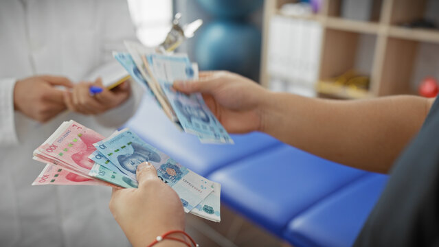 Two men exchange chinese yuan in an indoor clinical setting, highlighting healthcare payment.