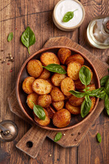 Baked potatoes. Potatoes with skin baked with olive oil and seasoning to golden color. Delicious snack served with sauce. Fast food. Side dish. Top view.