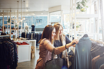 Smile, shopping and help customer with clothes for decision, sales or discount at luxury mall. Fashion, retail store or client with fabric at boutique for choice or advice with women talking at shop