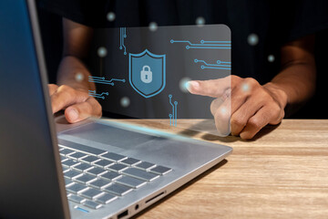 A man using a laptop with virtual screen of cyber security technology for protecting personal data and secure internet access concept.