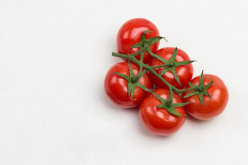 Red tomatoes on green branch and scissors
