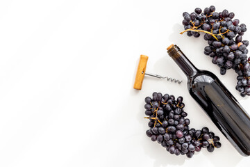 Bottle of wine with corkscrew and grapes. Wine background