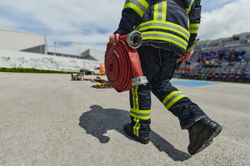 In a dynamic display of synchronized teamwork, firefighters hustle to carry, connect, and deploy...