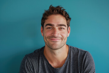 A close up portrait of a young man with a subtle smile