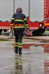 In a dynamic display of synchronized teamwork, firefighters hustle to carry, connect, and deploy firefighting hoses with precision, showcasing their intensive training and readiness for challenging