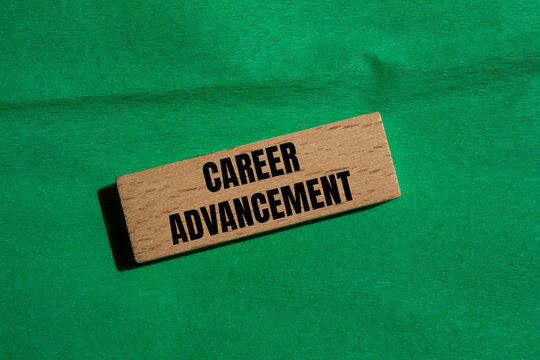 Career advancement message written on wooden block with green background. Conceptual career advancement symbol. Copy space.